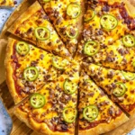 For the Birria Pizza Recipe image, if you're looking for an alt text, title, and description with a focus on SEO (similar to the Marry Me Chicken), here it is: Alt Text: Close-up of a sliced Birria Pizza on a wooden board, topped with melted cheese, shredded birria meat, and vibrant green jalapeño slices, sprinkled with chili flakes.