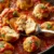 Juicy chicken meatballs simmering in marinara sauce, a cut-open meatball showing the tender interior. This photograph is part of a chicken meatball recipe and guide.